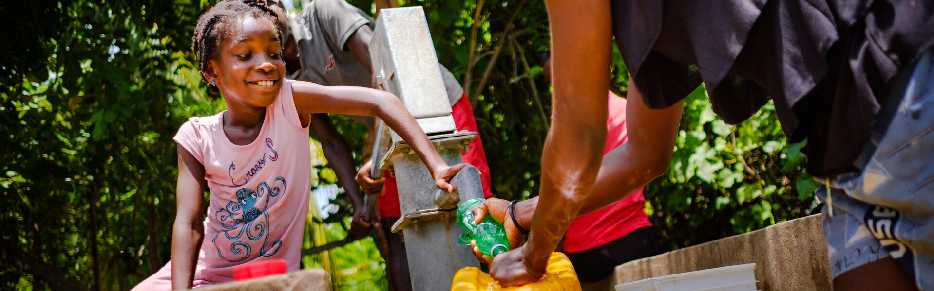 Ein Mädchen in Haiti freut sich über das fließende Wasser. Ein Mädchen in Haiti freut sich über das fließende Wasser.
