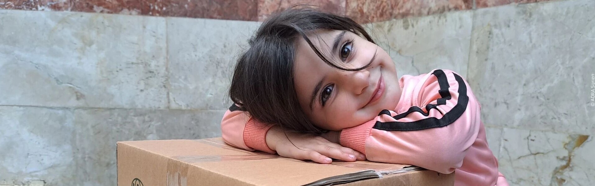 Mädchen aus Syrien freut sich über Hilfspaket Mädchen aus Syrien freut sich über Hilfspaket