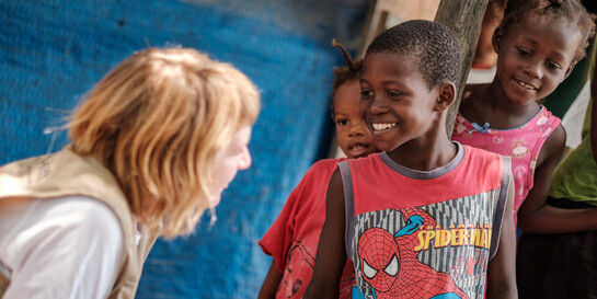 Helferin in Haiti spricht mit zwei kleinen Mädchen Helferin in Haiti spricht mit zwei kleinen Mädchen