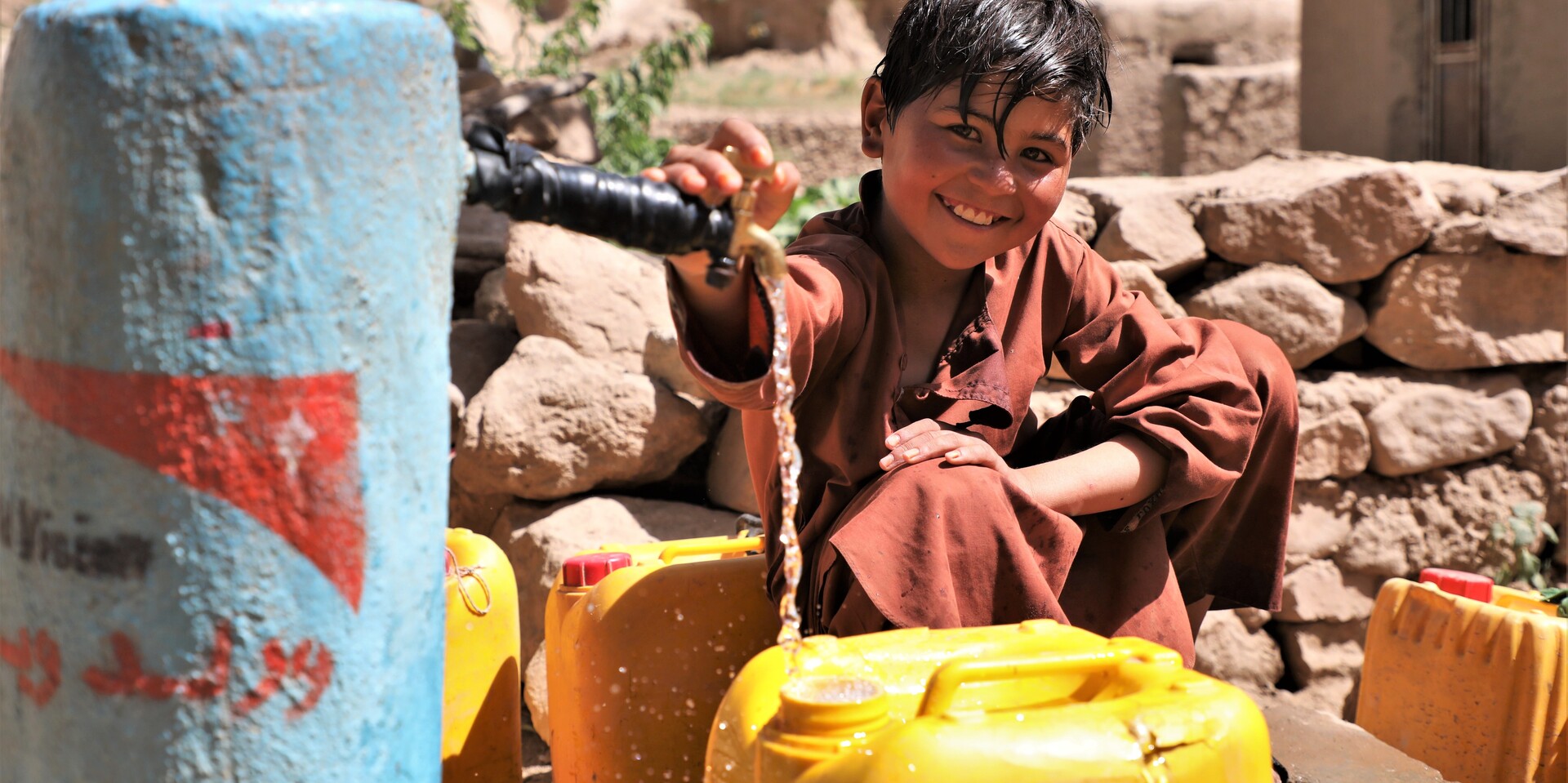 Ein Junge in Afghanistan füllt einen Kanister an einer Wasserstelle von World Vision Ein Junge in Afghanistan füllt einen Kanister an einer Wasserstelle von World Vision