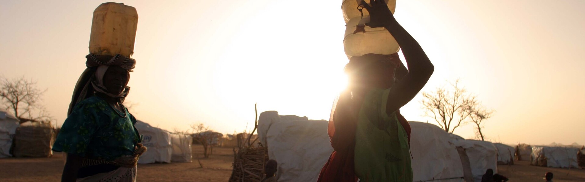 Zwei Menschen tragen im Sudan Wasserkanister (Archivfoto) Zwei Menschen tragen im Sudan Wasserkanister (Archivfoto)