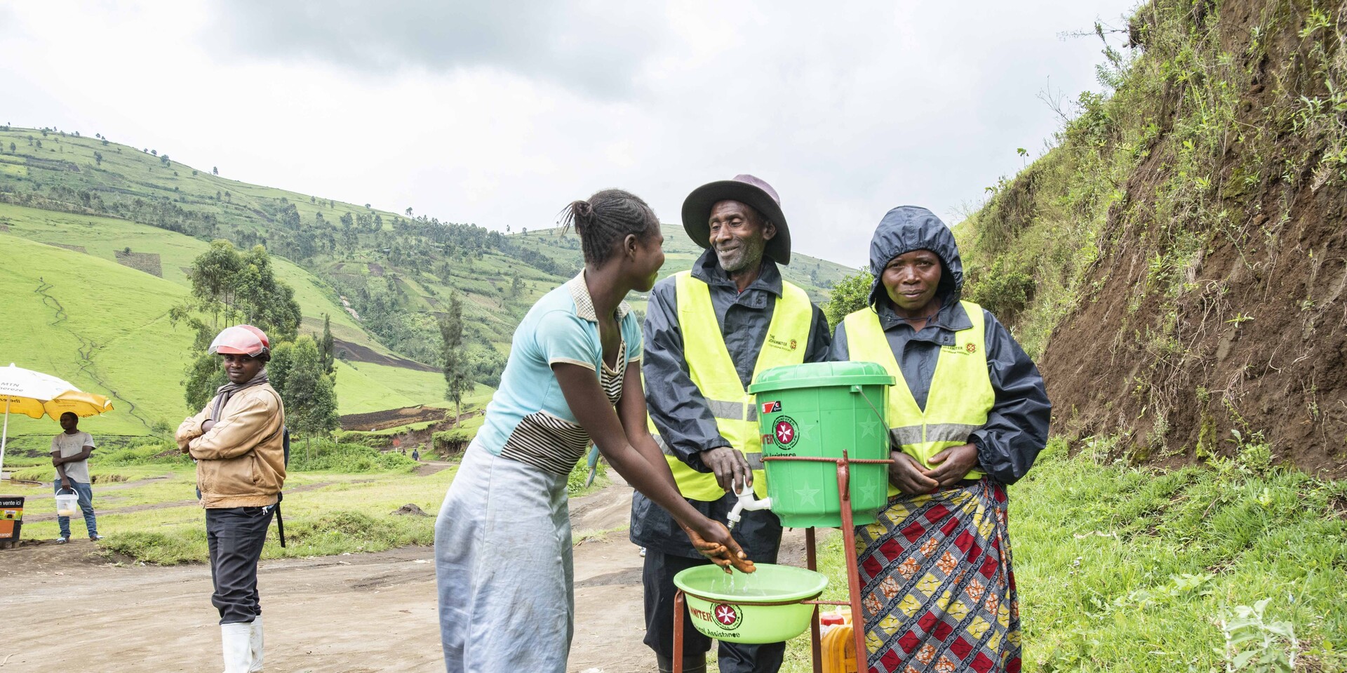 Helfer und eine Frau an einer Handwaschstation in der DR Kongo Helfer und eine Frau an einer Handwaschstation in der DR Kongo