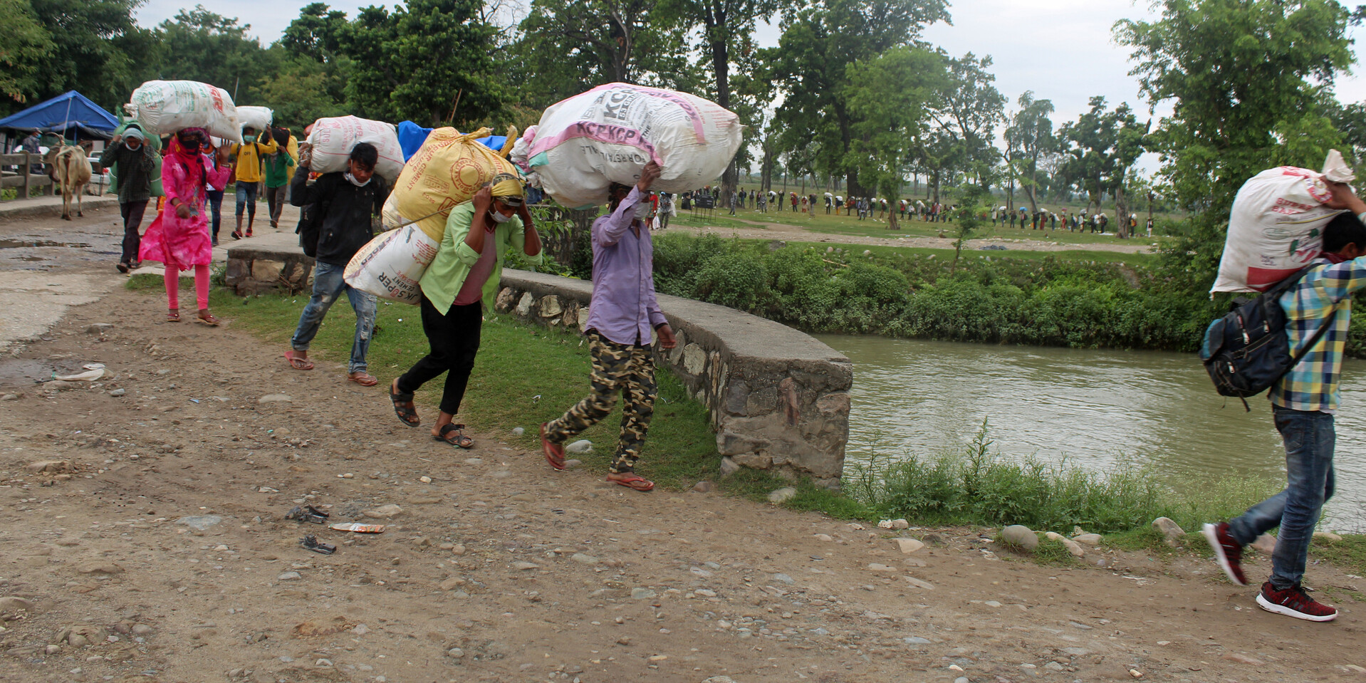 Die Arbeitsmigranten an der indisch-nepalesischen Grenze tragen ihr Hab und Gut in Säcken auf den Schultern Die Arbeitsmigranten an der indisch-nepalesischen Grenze tragen ihr Hab und Gut in Säcken auf den Schultern