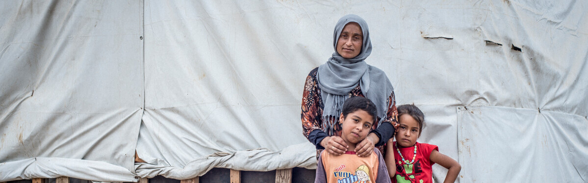 Eine aus Syrien geflüchtete Familie steht vor ihrer Notunterkunft Eine aus Syrien geflüchtete Familie steht vor ihrer Notunterkunft