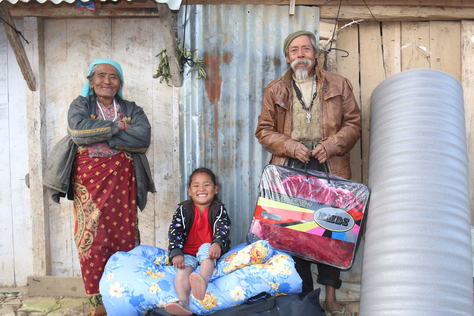 Nach dem Erdbeben in Nepal ist der Wiederaufbau im vollen Gange. Eine Familie sitzt vor ihrem neuen Haus. Nach dem Erdbeben in Nepal ist der Wiederaufbau im vollen Gange. Eine Familie sitzt vor ihrem neuen Haus.
