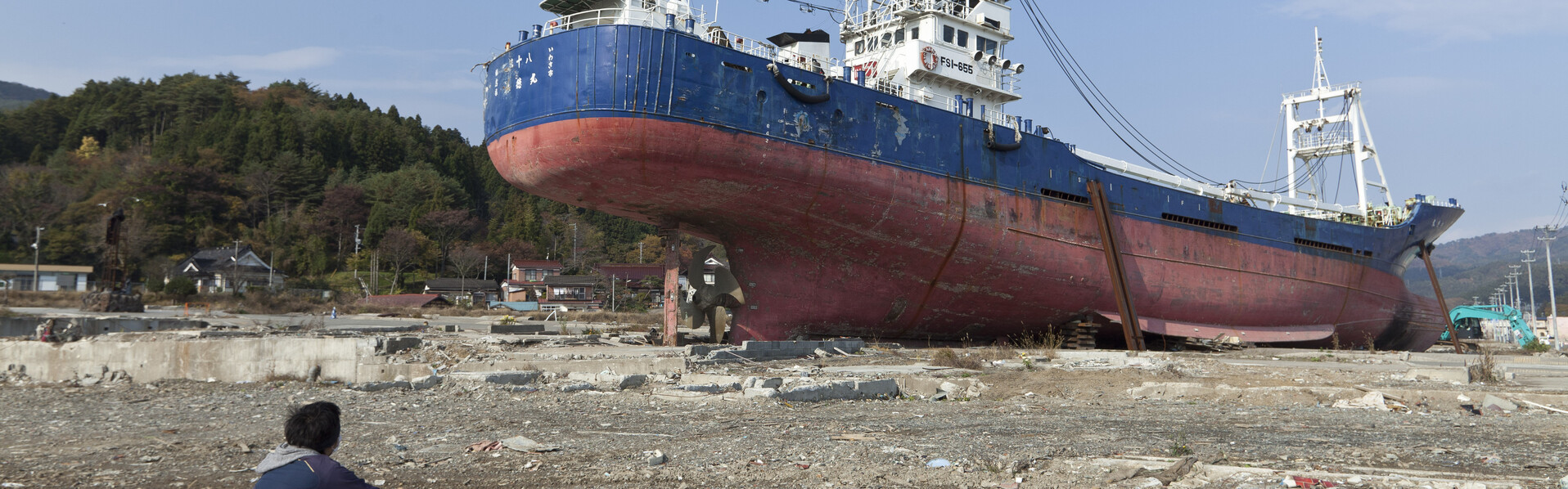Ein Mann blickt auf ein gestrandetes Schiff nach dem schweren Erdbeben und Tsunami in Japan Ein Mann blickt auf ein gestrandetes Schiff nach dem schweren Erdbeben und Tsunami in Japan