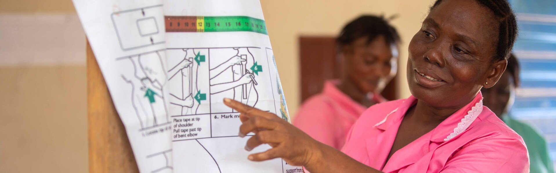 Eine Frau erklärt in Sierra Leone ein Plakat Eine Frau erklärt in Sierra Leone ein Plakat