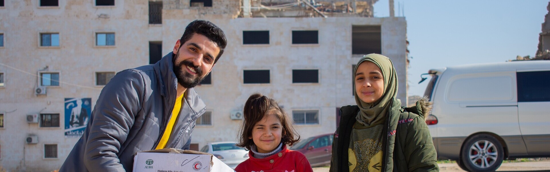 Ein Helfer von der Organisation ADRA übergibt Kindern aus dem Erdbebengebiet in Syrien Hygieneartikel Ein Helfer von der Organisation ADRA übergibt Kindern aus dem Erdbebengebiet in Syrien Hygieneartikel